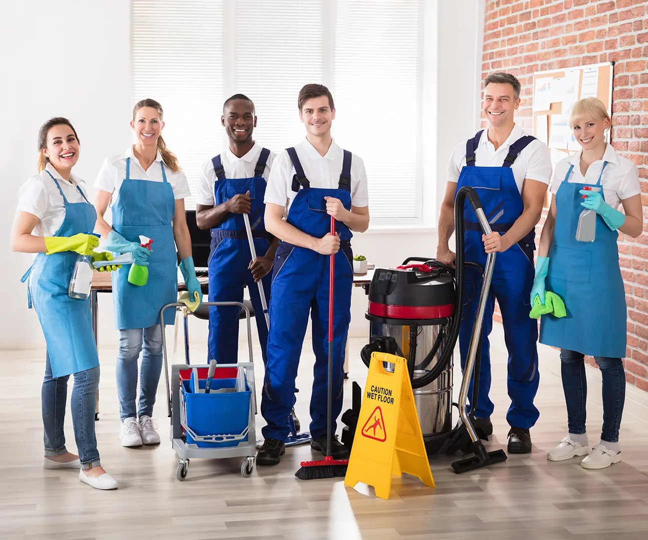 Cleaning crew posing with equipment indoors.