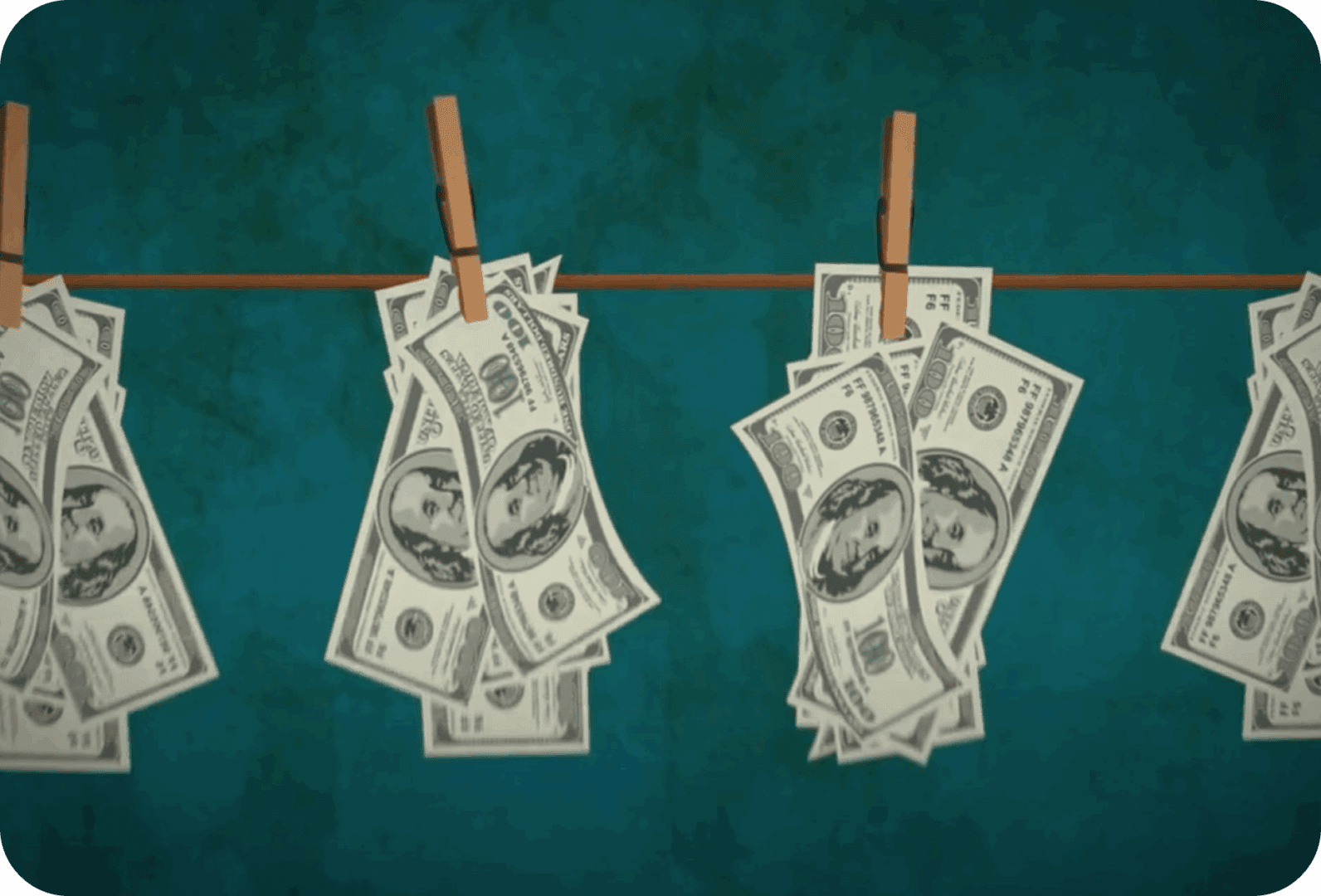 Dollar bills hanging on clothesline with clips.